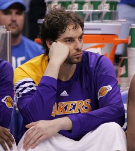 Pau Gasol in long sleeve Lakers warm-ups sits on the bench watching